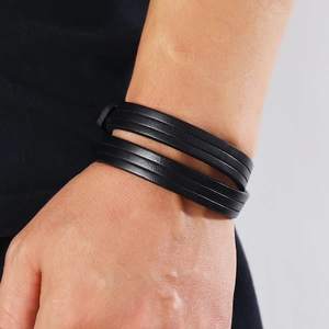 Close-up of a double-wrap black genuine leather bracelet with fine pressed textures
