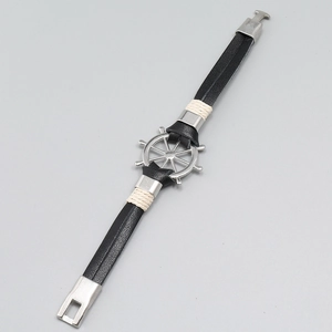 Detail of nautical black leather bracelet featuring a silver rudder charm and cord wrap