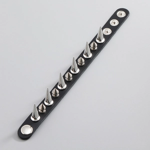 Détail d'un bracelet punk en cuir avec des clous argentés et des boutons pression réglables