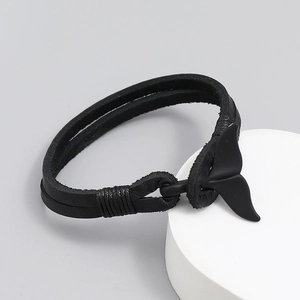 Black leather braided bracelet with matte black whale tail clasp on a white stand