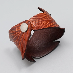 Macro shot of brown leather wide bracelet with leaf vein texture and metal button