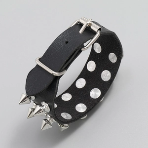 Détail d'un bracelet en cuir punk noir avec doubles pointes argentées et rivets