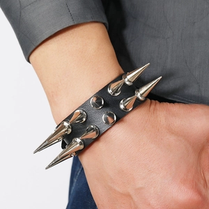 Nahaufnahme eines Punk-Lederarmbands mit zwei Reihen scharfer Silberstachel am Handgelenk