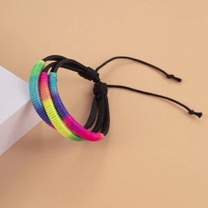 Bracelet en cuir tressé arc-en-ciel fait main avec cordon réglable sur fond pêche