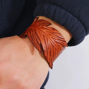 Close-up of a retro reddish brown leather bracelet featuring leaf vein pattern embossing