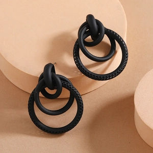 Detail of matte black hollowed texture double hoop earrings with knotted design