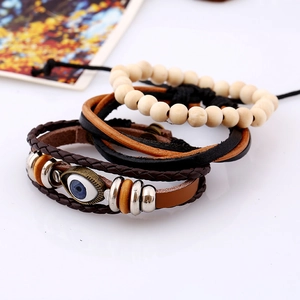 Macro detail of multi-layer leather bracelets with evil eye charm and wooden beads