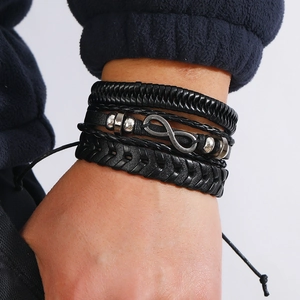 Detailed close-up of multi-layer woven black leather bracelet with silver infinity symbol