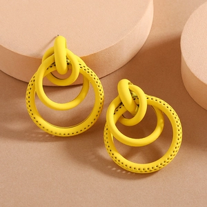 Detail of yellow matte layered hoop earrings with hollow dots in a modern geometric style