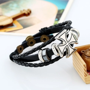 Close-up of vintage multi-layer braided leather bracelet with a silver cross charm