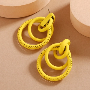 Detail of bright yellow triple-layer circular earrings with textured镂空 geometric design