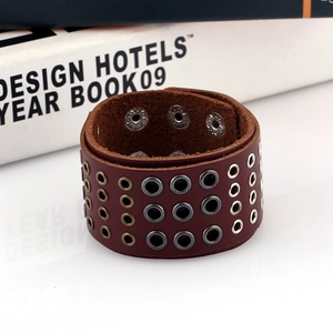 Punk style wide leather bracelet with triple row metallic eyelets on white background