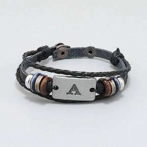 Macro view of multi-layer leather bracelet with beaded details and metal plate engraving