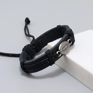 Detail of woven black leather bracelet with vintage silver rugby ball alloy charm