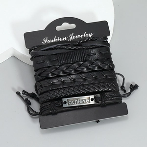 Detailansicht mehrlagiger schwarzer Lederarmbänder mit gravierter achieve Metallplakette