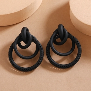 Macro shot of matte black triple-interlocked textured geometric hoop earrings