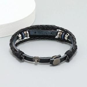 Detail of multi-layer black braided leather bracelet with silver beads and metal snap clasp