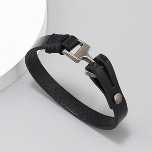 Detail of black leather bracelet featuring vintage silver hook clasp and rope wrapping