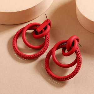 Detail of red matte geometric earrings featuring镂空textured double circles design
