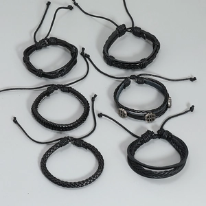 Detail von 6er-Set schwarzer Lederarmbänder mit geflochtenem Muster und Dollar-Anhänger