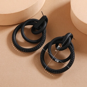 Detail view of large matte black nested hoop earrings showing the 5.2cm size and texture