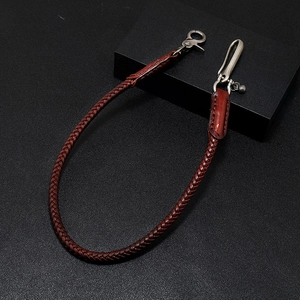 Macro detail of hand-woven brown leather waist chain with vintage silver metal hooks