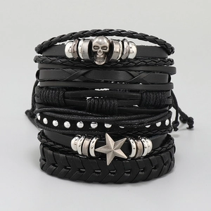 Detail of multi-layer black leather bracelets with skull and star charms in punk style
