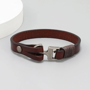 Detail of dark brown leather anchor bracelet with vintage silver metal hook and wrap cord