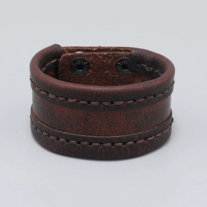 Detail view of retro brown leather bracelet with handmade stitching and metal snap buttons