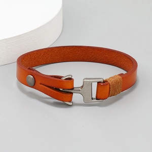 Detailed shot of an orange-brown leather bracelet featuring a minimalist metal hook clasp