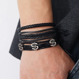 Nahaufnahme des mehrlagigen schwarzen Lederarmband-Sets mit silbernen Dollarzeichen