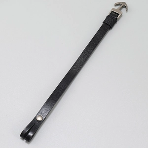 Detailed view of black leather anchor bracelet with silver metal buckle and pebble texture