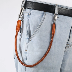 Close-up of brown hand-braided leather pants chain with silver clasp on denim