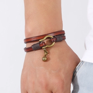 Detail of vintage brown double-layer leather bracelet with horseshoe U-shape buckle