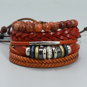 Detailed macro of multi-layered braided leather bracelet set with retro metal charms