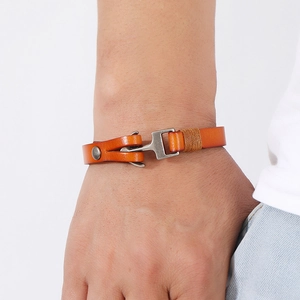 Macro detail of men's leather anchor bracelet with vintage metal hook clasp and orange cord