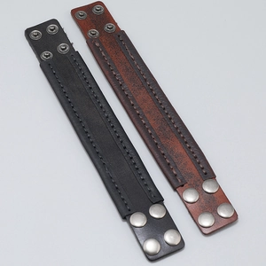 Detail of vintage leather bracelets with manual stitching and adjustable metal snaps
