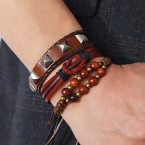Three-piece brown leather bracelet set with woven straps, wood beads and metal rivets