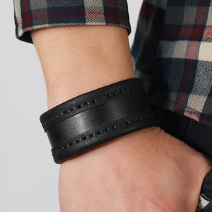Close-up of vintage black wide leather bracelet with detailed stitching for men