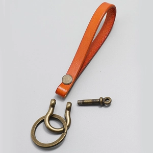 Macro view of vintage orange leather keychain components with antique bronze hardware