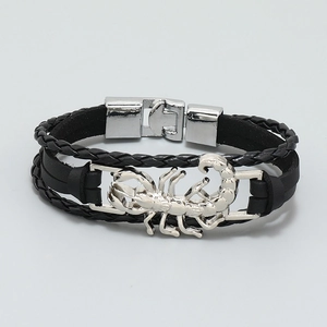 Detail of multi-layer black leather bracelet with silver scorpion charm and metal buckle