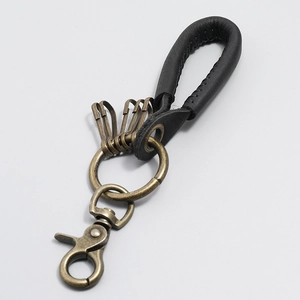 Detail of vintage hand-woven leather car keychain with bronze hooks and lobster clasp