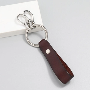 Detailed macro of vintage dark brown leather keychain with sturdy silver metal ring and clasps