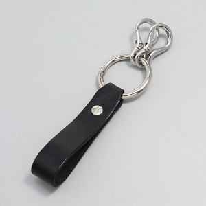 Detail of minimalist black leather keychain with silver metal ring and spring hooks