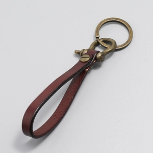 Detail view of retro wine red leather keychain with brass D-ring and polished metal ring