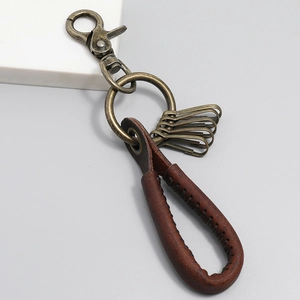 Macro view of vintage brown leather keychain with bronze lobster clasp and metal hooks