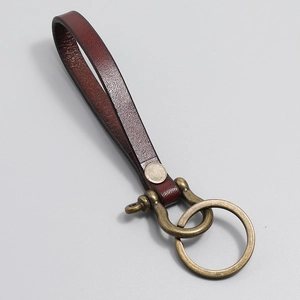 Detail of vintage burgundy leather keychain with brass horseshoe D-ring and key loop