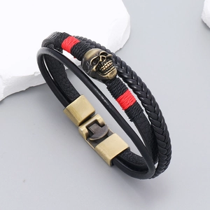 Bracelet multicouche en cuir avec un crâne en bronze et des détails de fils de soie rouge