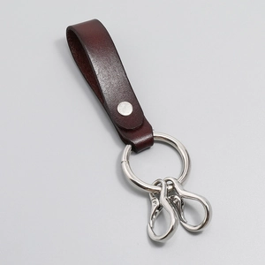 Detail of dark brown leather keychain with silver rivets and dual swivel lobster clasps