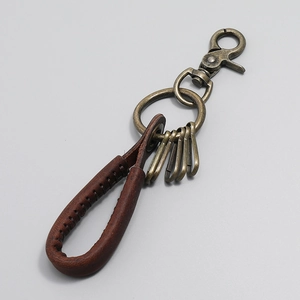 Detail of hand-woven vintage leather keychain with bronze metal clips and rustic texture